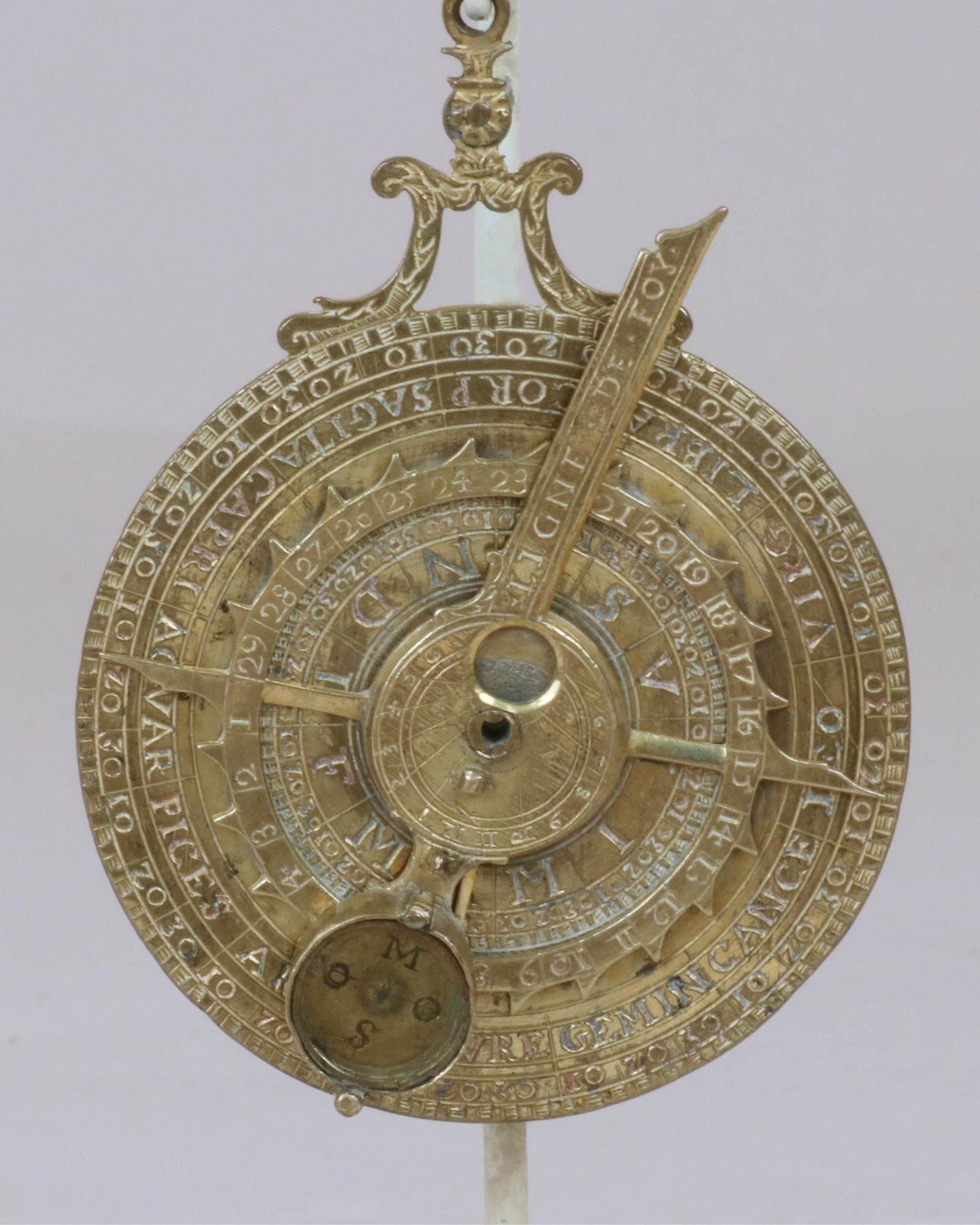 Engraved brass instrument with a compass inset.